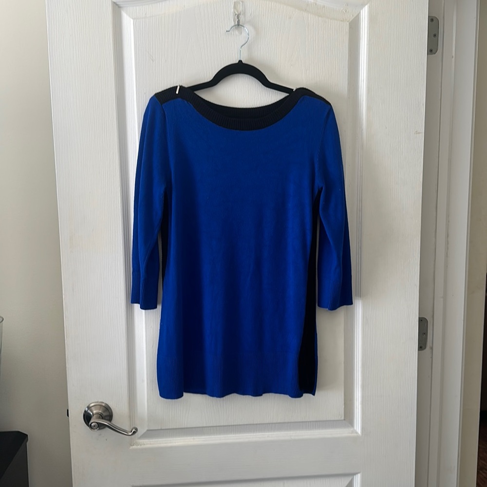 Slim fit blue sweater with black sides and zipper detail on shoulders.